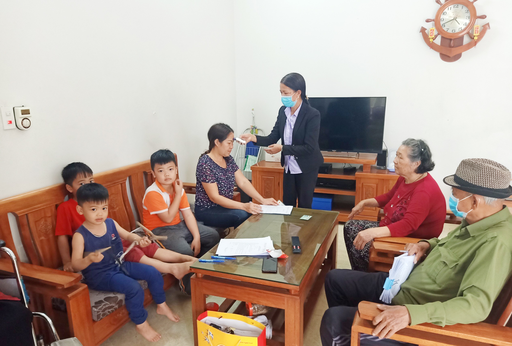 Đồng chí Ngô Thị Ánh, Bí thư Chi bộ, trưởng khu 6 đo thân nhiệt cho hộ gia đình ông La Văn Hơn trú tại địa bàn.