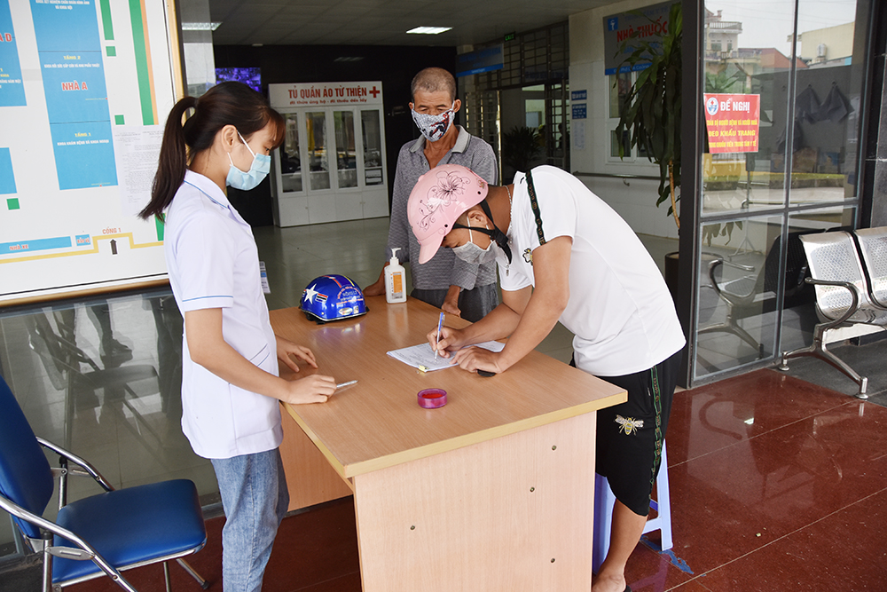 Người dân đến khám tại Trung tâm Y tế huyện Đầm Hà đều phải đo thân nhiệt và khai báo dịch tễ.