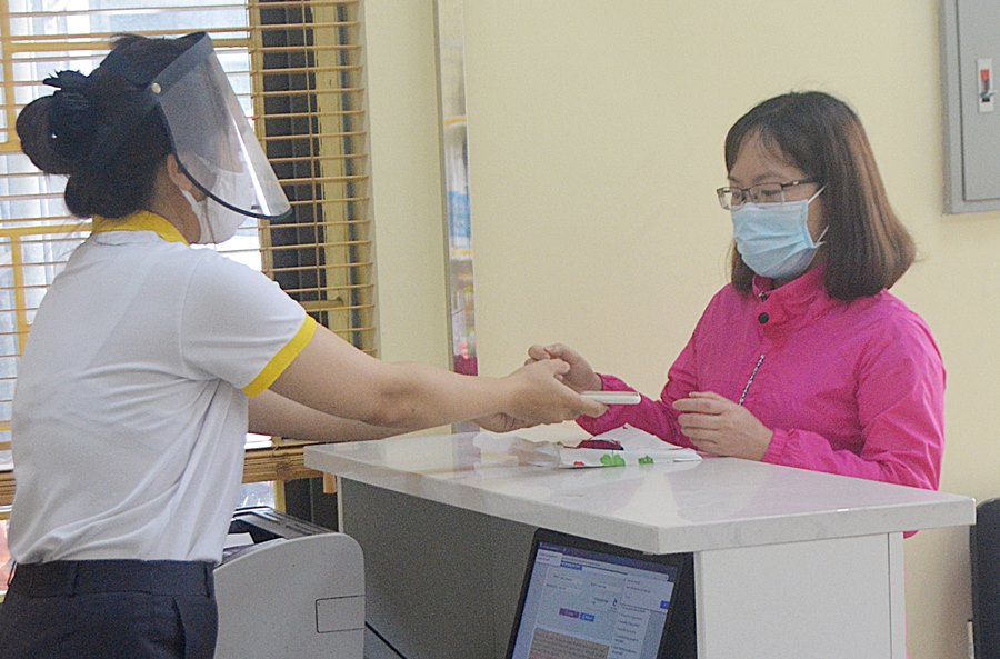 Cán bộ tại Bưu cực Hà Tu (TP Hạ Long) phục vụ người dân thực hiện dịch vụ của bưu điện.