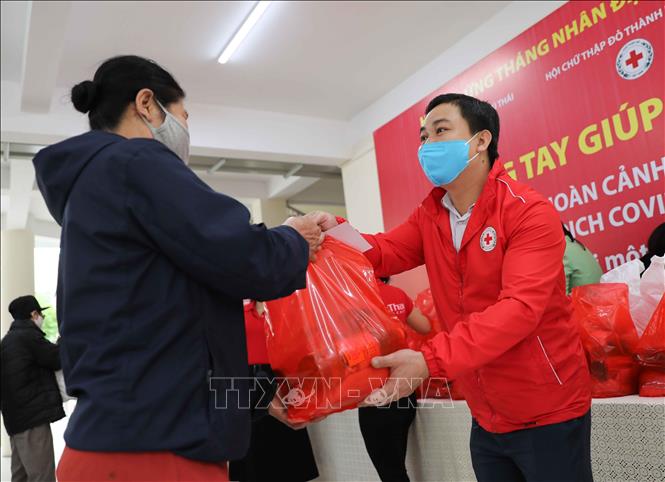 Đại diện Hội Chữ thập đỏ thành phố Hà Nội trao quà cho người có hoàn cảnh khó khăn do dịch COVID-19. Ảnh minh họa: Thanh Tùng/TTXVN