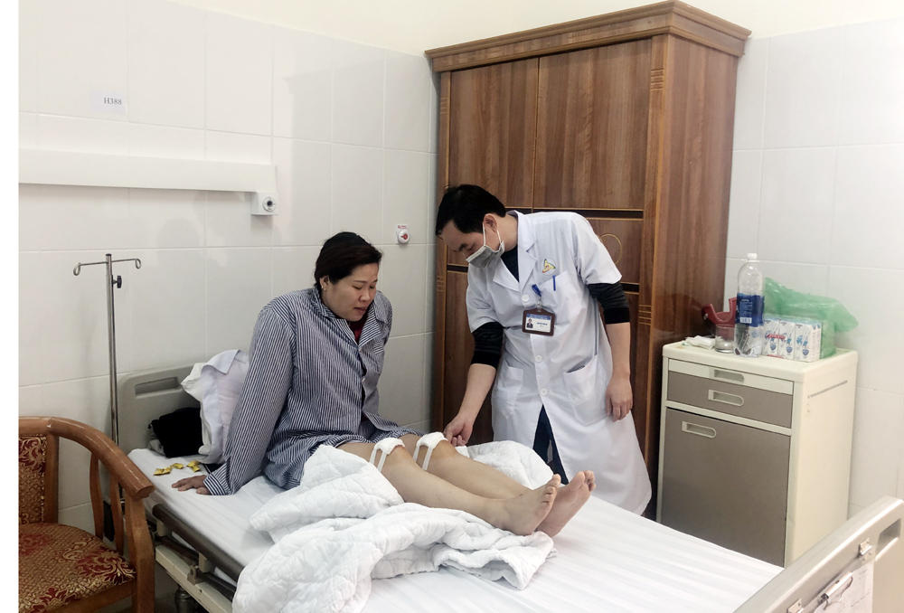 Nâng cao chất lượng khám chữa bệnh là một giải pháp để thu hút người dân tham gia BHYT. Trong ảnh: Bác sĩ Trung tâm y tế Đông Triều khám, chữa bệnh cho người dân.