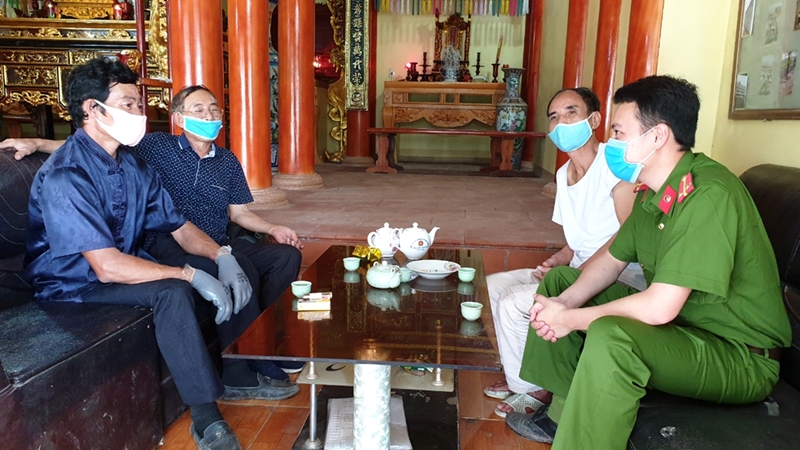 Ông Phạm Văn Đạt (ngoài cùng, bên trái) cùng đại diện ban giám tộc dòng họ Phạm Văn xã Đài Xuyên (huyện Vân Đồn) trao đổi các thông tin về ANTT trong dòng họ, trong thôn với Công an xã.
