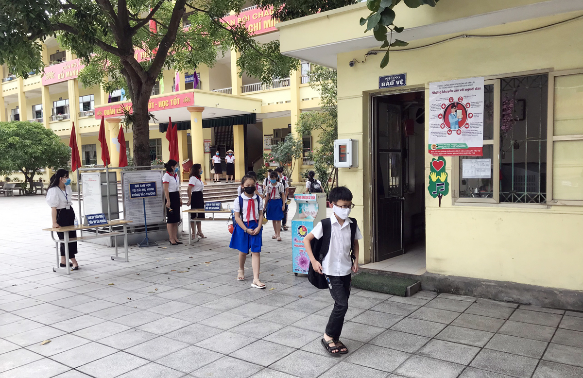Học sinh Trường Tiểu học Phan Bội Châu (TP Cẩm Phả) tan học được các giáo viên hướng dẫn giữ khoảng cách an toàn.
