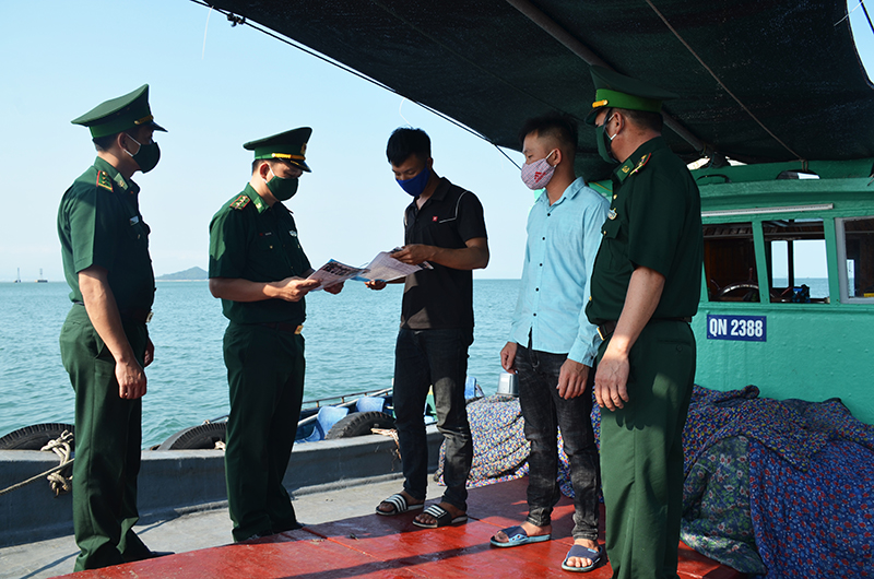 Cán bộ Đồn BPCK Cảng Vạn Gia tuyên truyền cho ngư dân về phòng chống dịch Covid-19