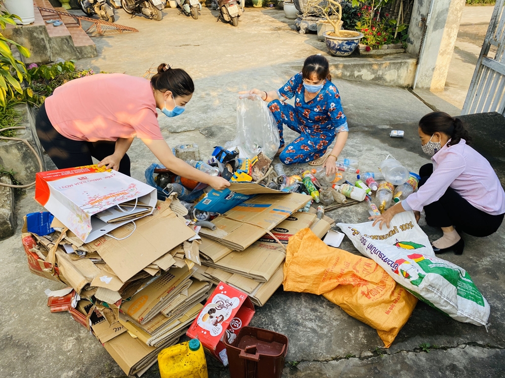 Bà Nguyễn Thị Xuân (ở giữa) cùng các hội viên phân loại phế liệu trong mô hình “Biến rác thành tiền” của chi hội.