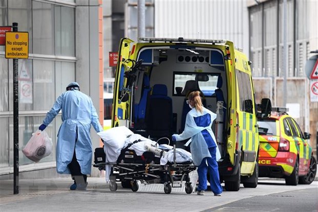 Nhân viên y tế chuyển bệnh nhân Covid-19 tới bệnh viện ở London, Anh ngày 18/4/2020. (Ảnh: AFP/ TTXVN)
