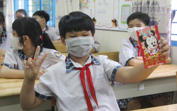 Học sinh lớp 5/10 Trường tiểu học Lê Đức Thọ, quận Gò Vấp, TP.HCM vui mừng nhận lì xì trong ngày đầu trở lại trường - Ảnh: NHƯ HÙNG