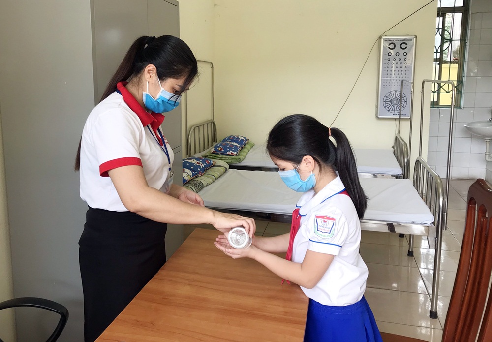 Bộ phận y tế học đường tại Trường Tiểu học Phan Bội Châu (TP Cẩm Phả) hướng dẫn học sinh sử dụng nước rửa tay khô đúng cách. 
