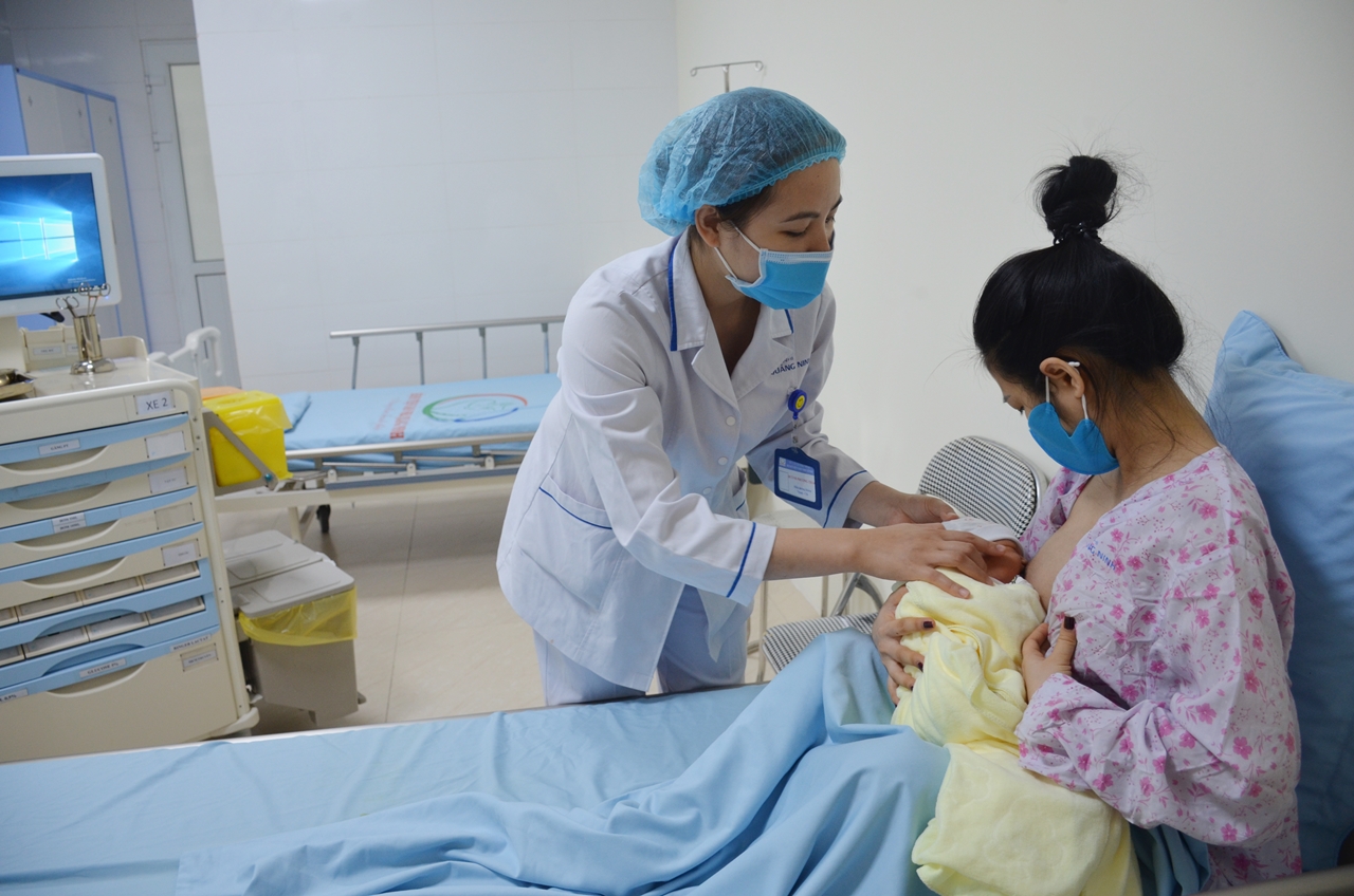 Chị Lê Thị Tuyết (TP Hải Dương) được nhân viên y tế Bệnh viện Sản Nhi hướng dẫn cho con bú mẹ.