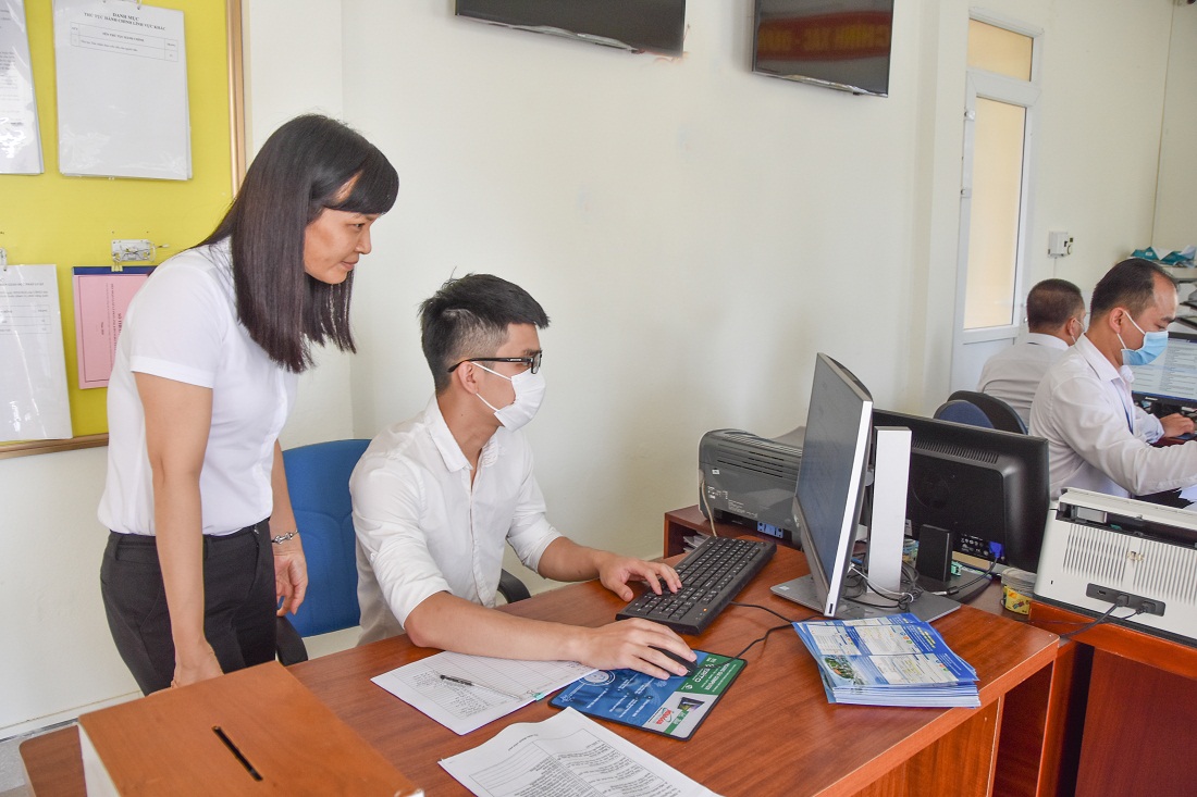 Đồng chí Bí thư Đảng ủy kiêm Chủ tịch UBND phường KaLong (bên trái) giải quyết công việc tại Bộ phận tiếp nhận và trả kết quả hiện đại của phường.