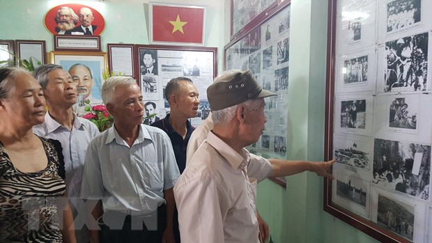 Ông Trần Văn Cao giới thiệu các bức ảnh của Bác Hồ cho khách tham quan. (Ảnh: Đinh Thuận/TTXVN)