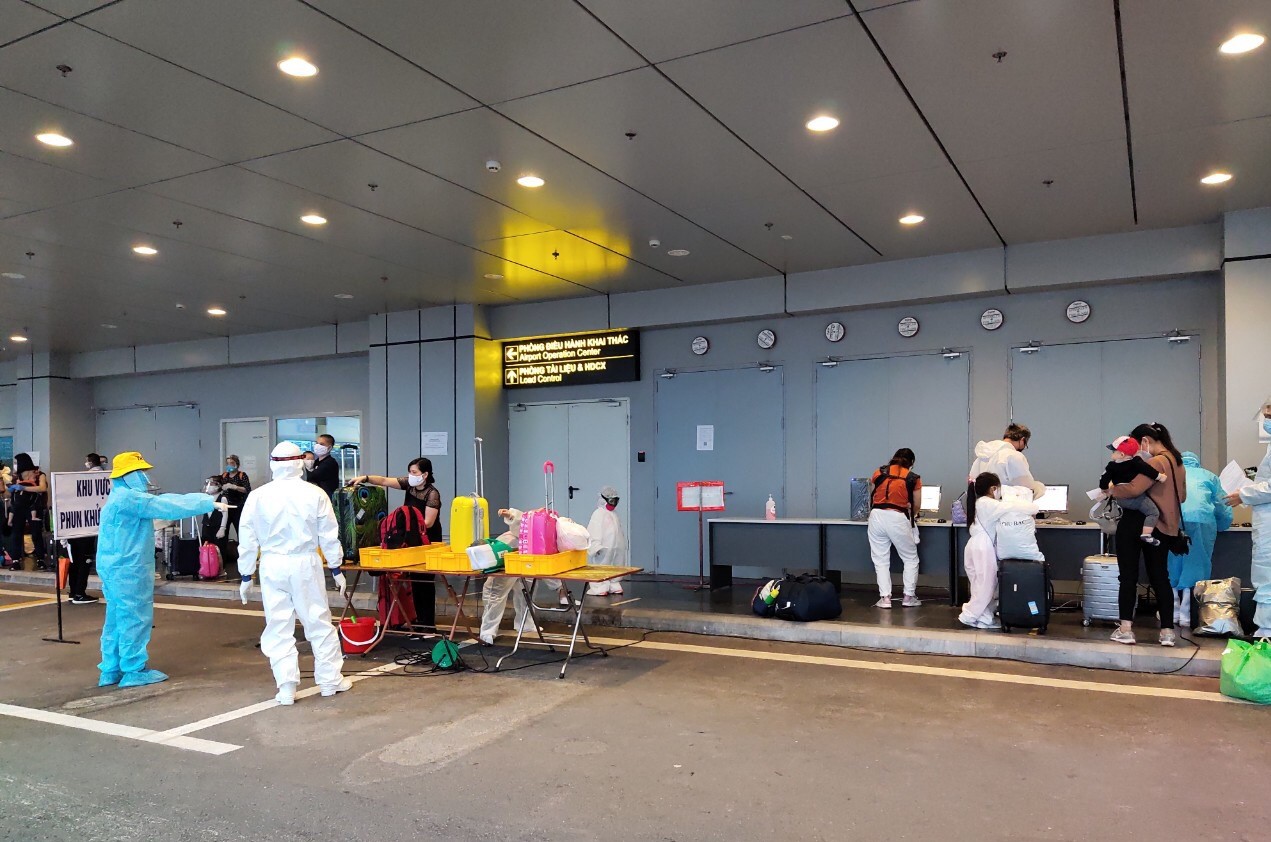 Hành khách làm thủ tục kiểm tra y tế bên ngoài nhà ga