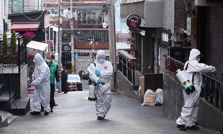 Các nhân viên vệ sinh khử trùng đường phố và các địa điểm công cộng tại khu Itaewon ở Seoul, Hàn Quốc hôm 12/5. Ảnh: Reuters.