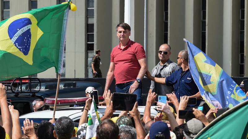 Tổng thống Brazil Bolsonaro (áo đỏ) giữa những người biểu tình phản đối các chính sách thắt chặt phòng, chống dịch Covid-19. Ảnh: AFP/Getty Images