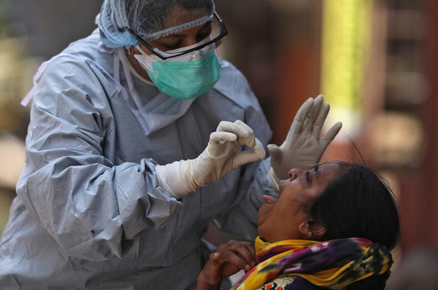 Bác sĩ Ấn Độ lấy mẫu xét nghiệm COVID-19 cho một người dân ở thành phố Mumbai. Ảnh: Reuters