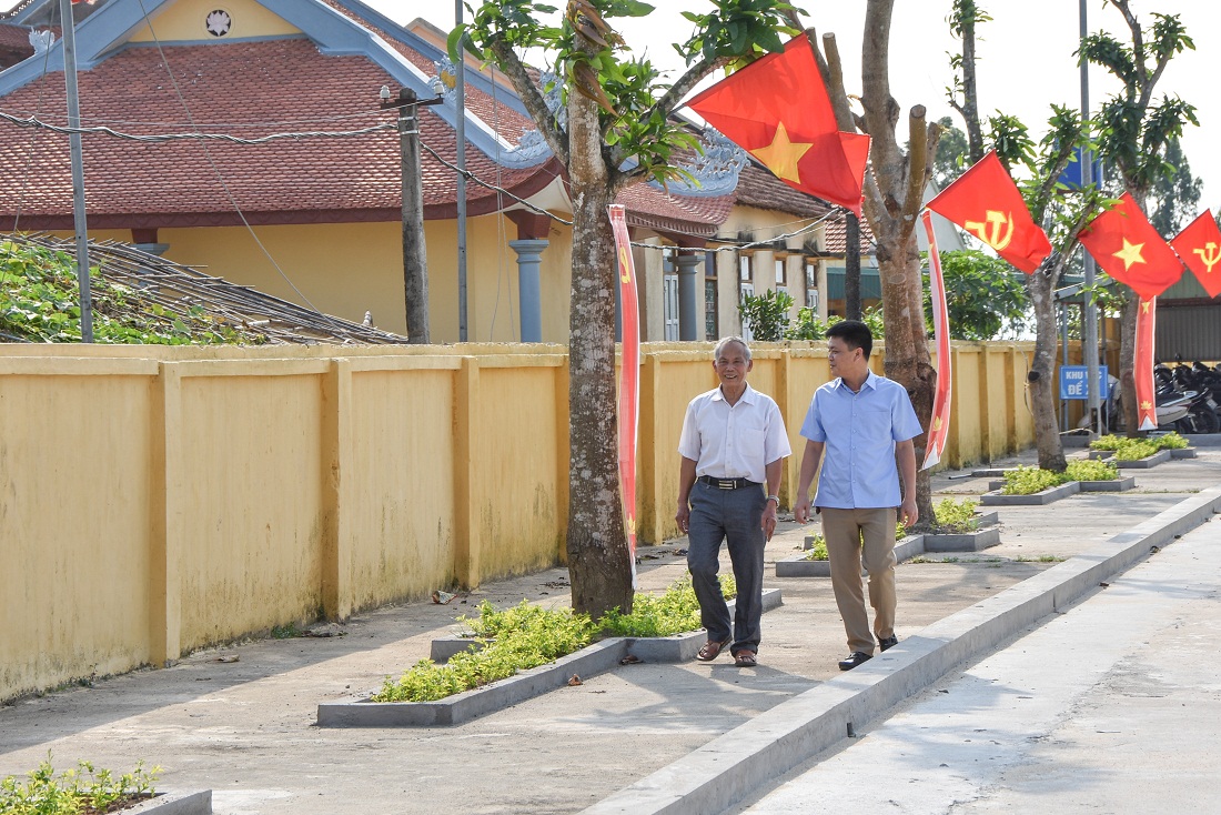 Lãnh đạo xã Vạn Ninh, TP Móng Cái (phải) nắm tình hình xây dựng NTM ở khu dân cư qua cán bộ thôn.