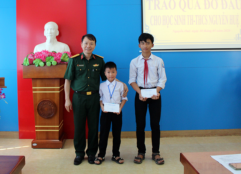 Lãnh đạo BCH Quân sự TX Đông Triều trao tặng học bổng đỡ đầu cho các em học sinh ở trường Tiểu học và THCS Nguyễn Huệ