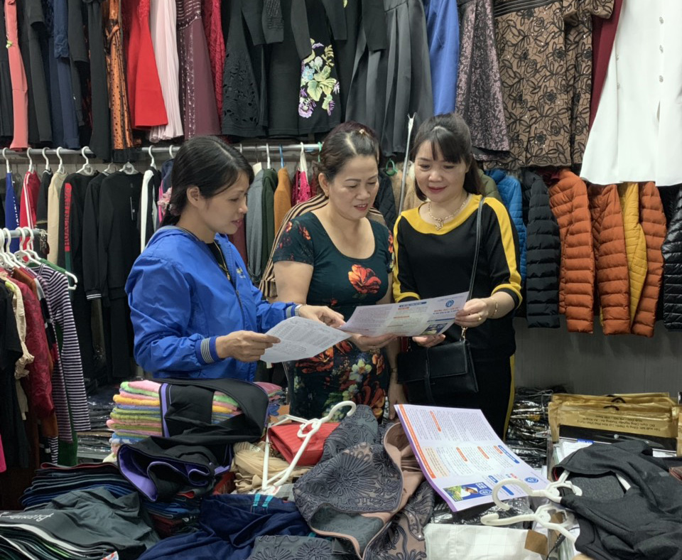 Cán bộ BHXH TP Uông Bí tuyên truyền về chính sách BHXH tự nguyện cho tiểu thương tại chợ Trưng Vương.