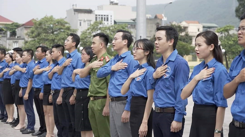 Đại úy Lê Văn Vinh (mặc cảnh phục) cùng các đoàn viên thanh niên TP Cẩm Phả hát quốc ca chào mừng 103 năm Ngày sinh Nhật Bác.