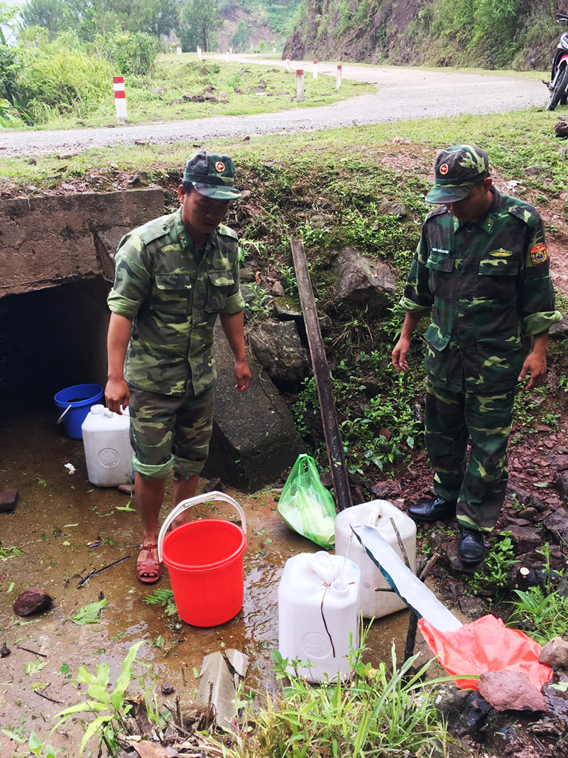 Thiếu tá Nguyễn Đắc Đạt (bên trái) cùng đồng đội xuống khe suối lấy nước về sinh hoạt.