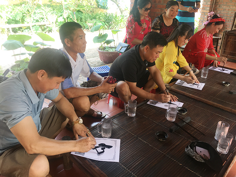Du khách tham gia trải nghiệm vẽ thư pháp tại Khu du lịch Quảng Ninh gate.