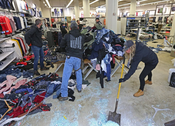 Các nhân viên của Odd Navy dọn dẹp mảnh kính và xếp lại quần áo tại một cửa hàng ở Seattle sau bạo loạn ngày 30-5-2020 - Ảnh: Seattle Times