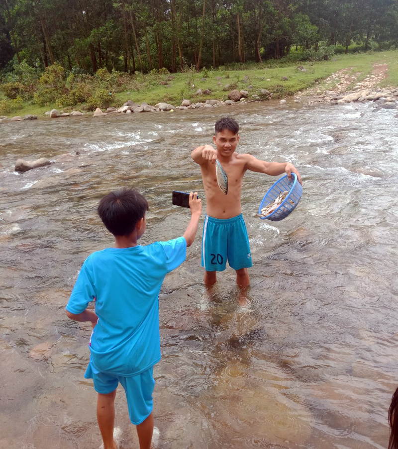Trẻ em xã Quảng Đức ra suối vớt cá chết.