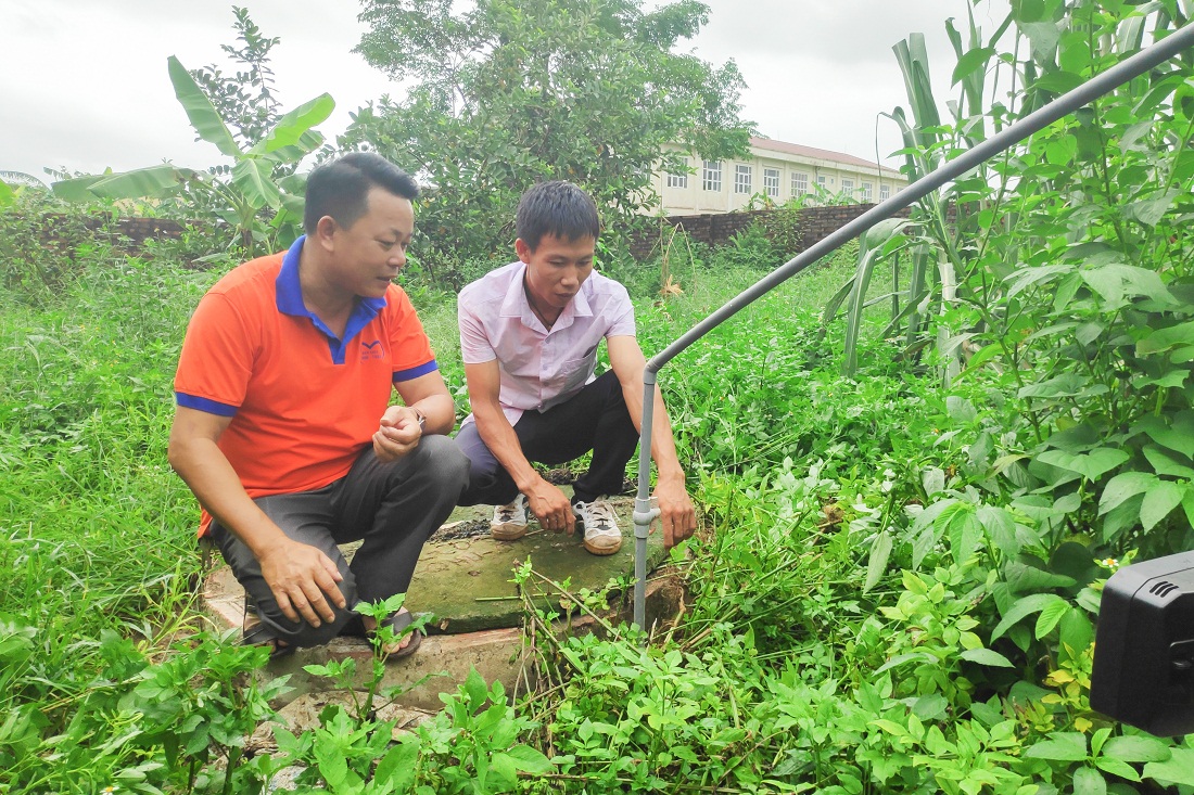 Cán bộ xã Quảng Lợi, huyện Đầm Hà (bên trái) kiểm tra bể biogas của hộ chăn nuôi gia súc, gia cầm tại địa phương.