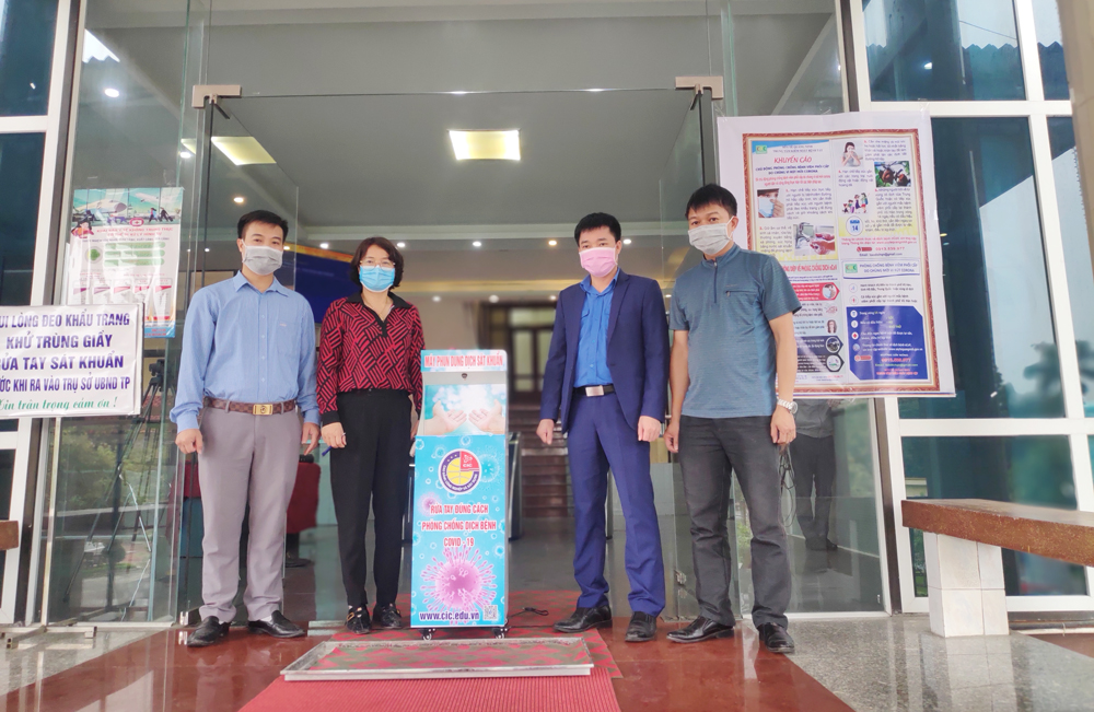Đại diện Trường CĐ Công nghiệp và Xây dựng trao tặng thiết bị phun sát khuẩn tay tự động do trường chế tạo cho UBND TP Uông Bí.