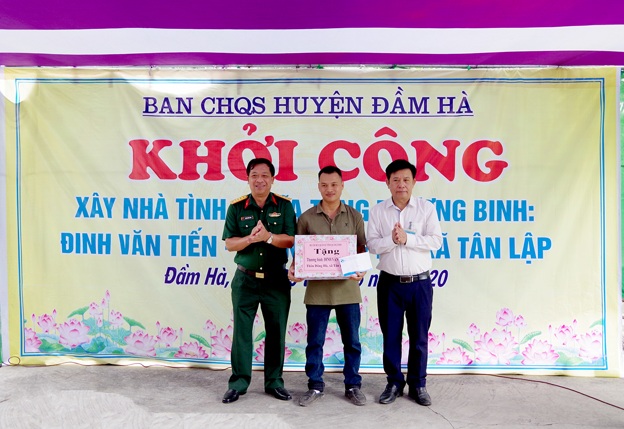 Thủ trưởng Phòng Chính trị Bộ CHQS tỉnh, lãnh đạo UBND huyện Đầm Hà tặng quà cho gia đình trong ngày khởi công.