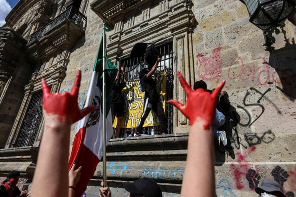 Người biểu tình tụ tập phản đối bên ngoài trụ sở chính quyền bang Jalisco để đòi công lý cho Giovanni Lopez, một công nhân xây dựng đã chết sau khi bị cảnh sát bắt và đánh vì không đeo khẩu trang ở nơi công cộng - Ảnh: REUTERS