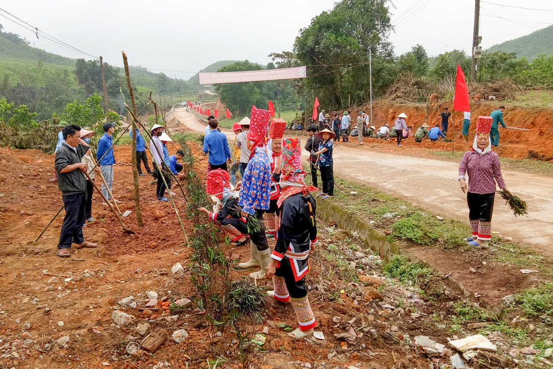 Cán bộ, nhân dân xã Quảng Lâm tham gia trồng hoa, cây xanh tạo cảnh quan tuyến đường trục chính của xã. 