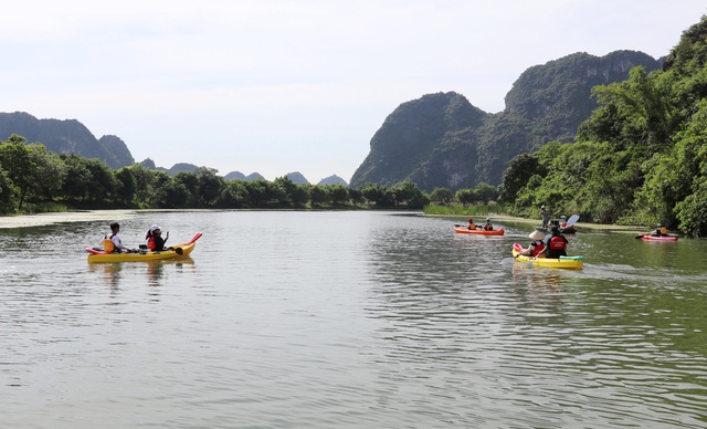 Khung cảnh tuyệt đẹp ở Tràng An nổi bật thêm những chiếc thuyền kayak đủ màu sặc sỡ trôi êm đềm trên sông để ngắm cảnh hùng vĩ nơi đây.
