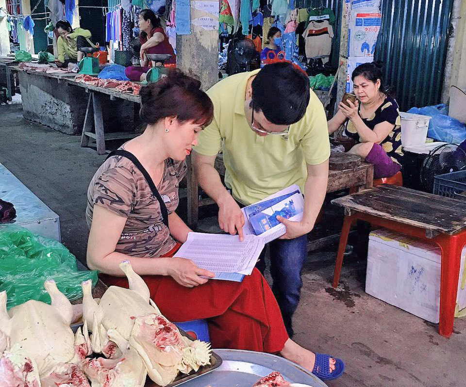 Nhân viên Bưu điện huyện Tiên Yên tuyên truyền về BHXH tự nguyện tại chợ Đông Ngũ (Tiên Yên)