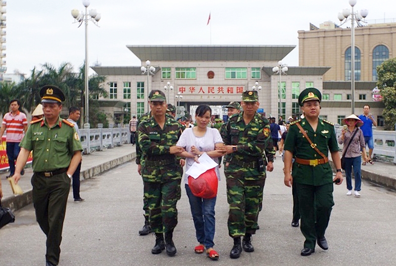 Lực lượng chức năng Việt Nam áp giải đối tượng phạm tội mua bán người qua biên giới. Ảnh: Nguyễn Khánh (Công an tỉnh)