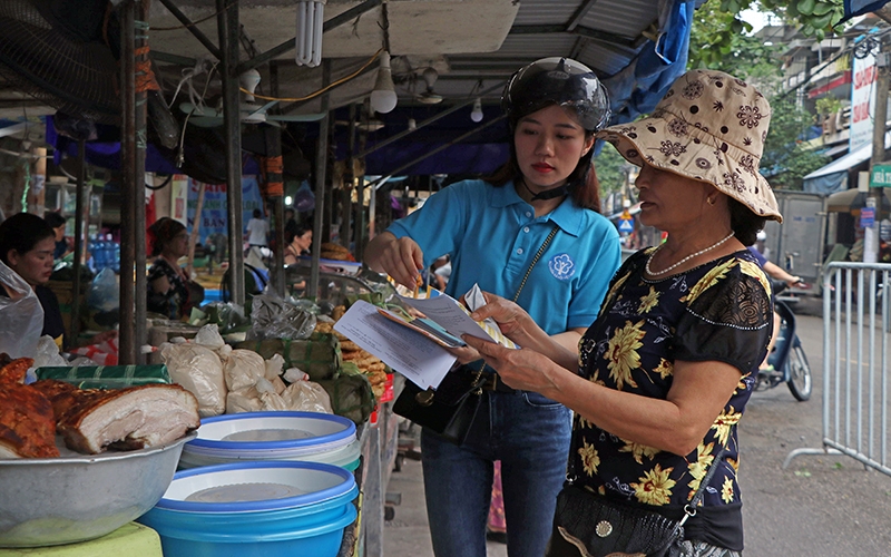  Cán bộ BHXH tỉnh Hải Dương tuyên truyền, vận động tiểu thương tham gia BHXH ở một khu chợ dân sinh. Ảnh: MẠNH MINH