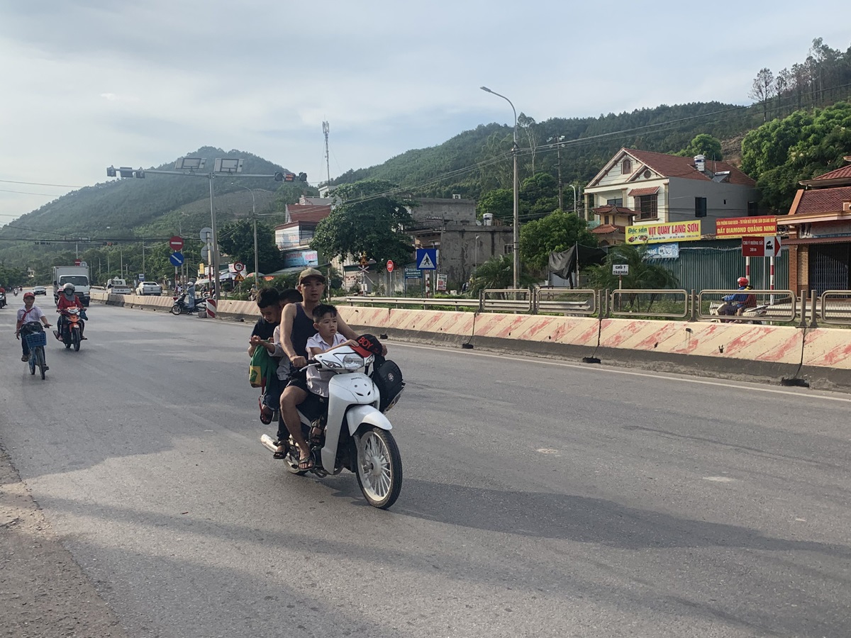 Nhiều phụ huynh vẫn chủ quan chở con trên xe mô tô và ngồi phía trước. Ảnh chụp tại phường Đại Yên (TP Hạ Long)