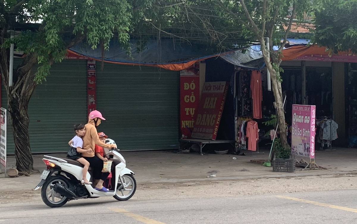 Phụ huynh chở 2 con trên xe mô tô nhưng không đội mũ bảo hiểm. Ảnh chụp tại xã Quảng Long (Hải Hà)