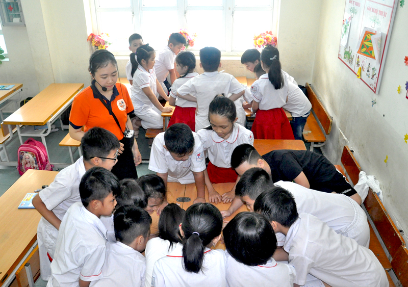 Nhân viên Công ty CP Giáo dục sáng tạo Hạ Long hướng dẫn học sinh lớp 3a6, Trường Tiểu học Quang Trung (Hạ Long) cách làm việc theo nhóm để trình bày các biện pháp đảm bảo an toàn cho bản thân khi xẩy ra mưa bão, sấm sét.