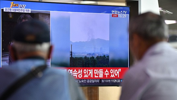 Người dân ở Seoul, Hàn Quốc, theo dõi thông tin về vụ nổ văn phòng liên lạc chung liên Triều ngày 16/6. Ảnh: AFP.
