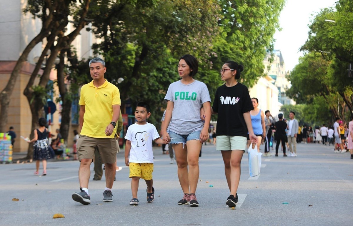 Nhiều gia đình đưa các em nhỏ đi chơi trên phố đi bộ nhân ngày Quốc tế thiếu nhi. (Ảnh: Thành Đạt/TTXVN)