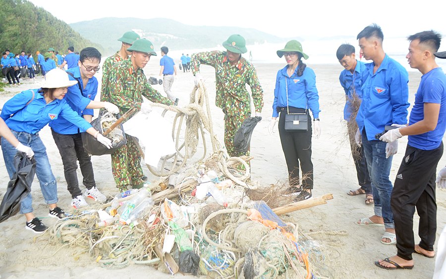 Đoàn viên thanh niên và lực lượng vũ trang tham gia dọn các loại rác thải tại bãi biển Trường Chinh xã Ngọc Vừng.