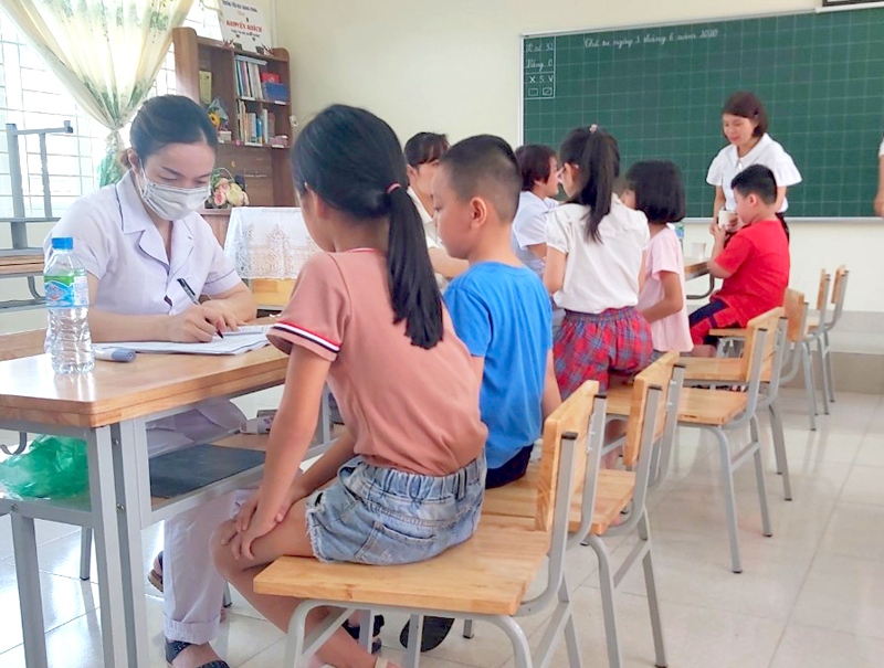 Cán bộ, nhân viên Trạm Y tế phường Hồng Hải (TP Hạ Long) nhập thông tin của học sinh Trường Tiểu học Quang Trung trước khi tiêm bổ sung vắc xin phòng bệnh bạch hầu- uốn ván đợt 2.
