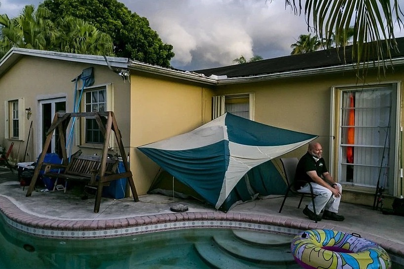 John Delgado bên cạnh túp lều sau sân nhà riêng ở Homestead, bang Florida, hôm 28/6. Ảnh: New York Times.