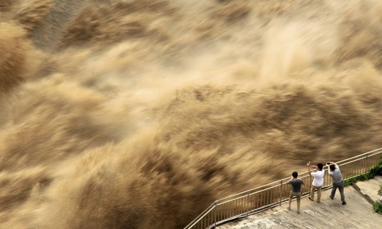 Người dân theo dõi cảnh xả lũ đập Tam Môn Hạ ở tỉnh Hà Nam, Trung Quốc hôm 30/6. Ảnh: AP.