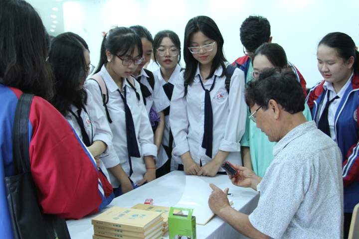 Nhà văn Dương Hướng ký tặng sách cho học sinh.