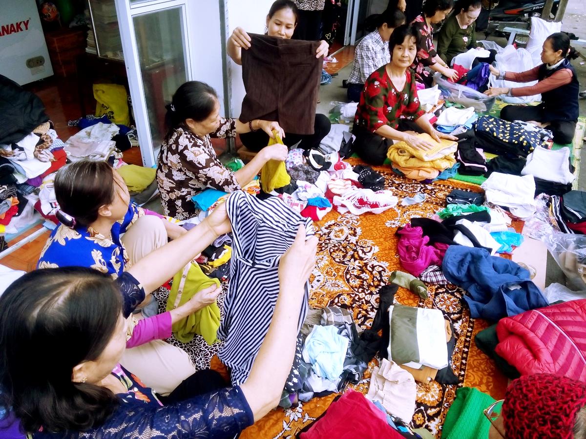 Chị em phụ nữ tiếp nhận quần áo từ thiện tại cửa hàng 