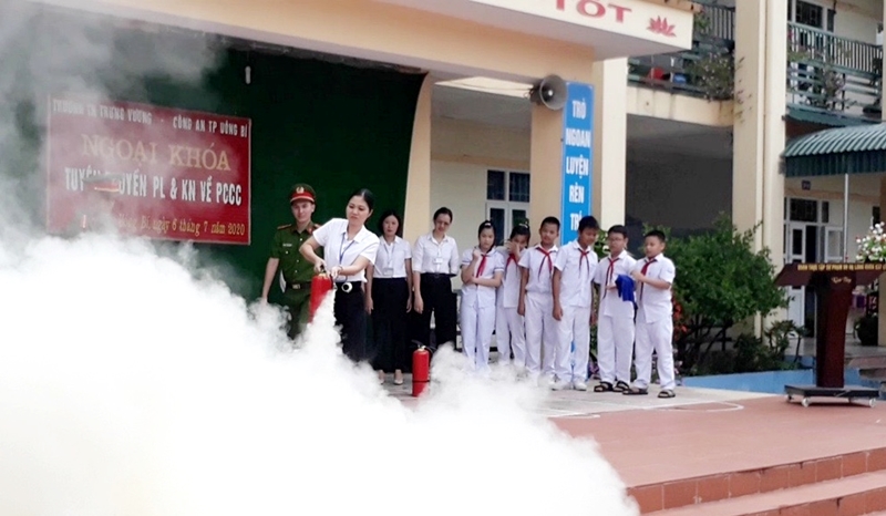 Giáo viên Trường Tiểu học Trưng Vương, TP Uông Bí được hướng dẫn và thực hành thao tác sử dụng bình chữa cháy.
