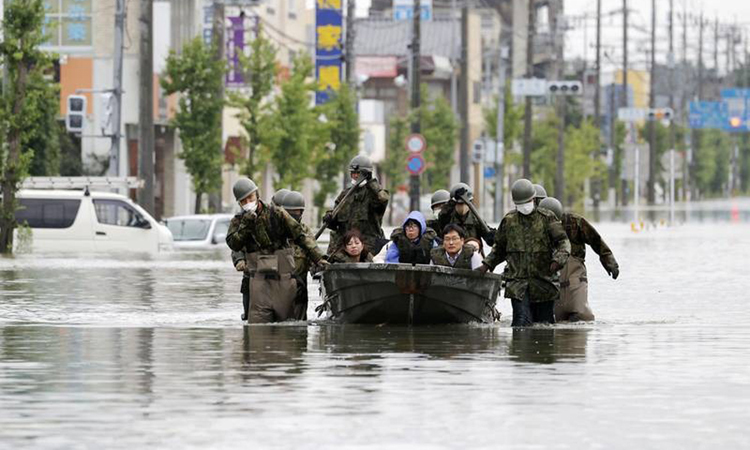 Binh sĩ Lực lượng Phòng vệ Nhật Bản sơ tán người dân tại vùng ngập lũ ở thành phố Omuta, tỉnh Fukuoka hôm nay. Ảnh: Kyodo.