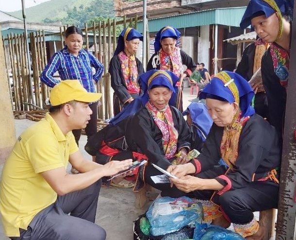 Nhân viên Bưu điện huyện Ba Chẽ tư vấn cho người dân tham gia BHXH tự nguyện tại chợ dân sinh xã Thanh Lâm.